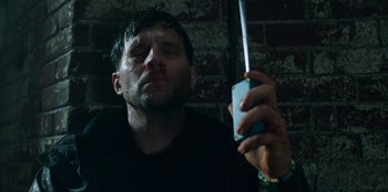 Movie still from “Lou” (2022), directed by Anna Foerster – A man with his eyes closed looking at a cell phone; Close Up shot, Low angle