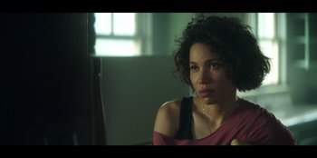 Movie still from “Lou” (2022), directed by Anna Foerster – A woman sitting in front of a window in a room; Close Up shot, Over the shoulder angle