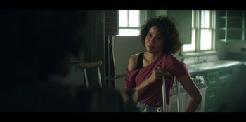 Movie still from “Lou” (2022), directed by Anna Foerster – A woman standing in front of a mirror in a room; Medium shot, Over the shoulder angle