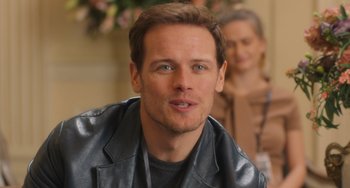 Movie still from “Love Again” (2023), directed by Jim Strouse – A person wearing a leather jacket; Close Up shot, Over the shoulder angle