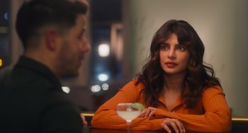 Movie still from “Love Again” (2023), directed by Jim Strouse – A man and a woman sitting at a table with a drink; Close Up shot, Over the shoulder angle