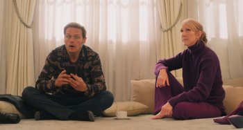 Movie still from “Love Again” (2023), directed by Jim Strouse – A man and a woman sitting on the floor; Medium shot, Over the shoulder angle