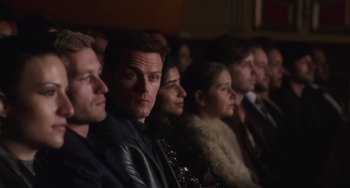 Movie still from “Love Again” (2023), directed by Jim Strouse – A group of men and women sitting in front of a camera; Medium shot, High angle