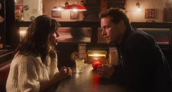 Movie still from “Love Again” (2023), directed by Jim Strouse – A man and a woman sitting at a table in front of each other; Close Up shot, Over the shoulder angle