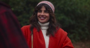 Movie still from “Love Again” (2023), directed by Jim Strouse – A woman wearing a red coat and a white hat; Close Up shot, Over the shoulder angle