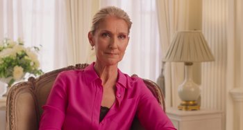 Movie still from “Love Again” (2023), directed by Jim Strouse – An older woman wearing a pink shirt sitting in a chair; Close Up shot, Low angle