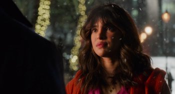 Movie still from “Love Again” (2023), directed by Jim Strouse – A woman with long brown hair wearing a pink shirt; Close Up shot, Over the shoulder angle