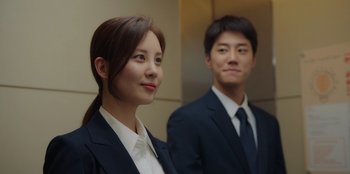 Movie still from “Love and Leashes” (2022), directed by Hyeon-jin Park – A woman and a man in business suits; Close Up shot, Low angle