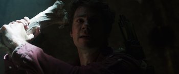Movie still from “Love and Monsters” (2020), directed by Michael Matthews – A person holding a bow and arrow; Close Up shot, Low angle