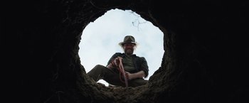 Movie still from “Love and Monsters” (2020), directed by Michael Matthews – A man sitting in a hole holding a rope; Close Up shot, Low angle