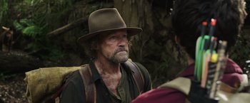 Movie still from “Love and Monsters” (2020), directed by Michael Matthews – An old man with a beard wearing a brown hat; Close Up shot, Over the shoulder angle