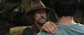 Movie still from “Love and Monsters” (2020), directed by Michael Matthews – An older man wearing a brown hat is looking at a younger man; Close Up shot, Over the shoulder angle