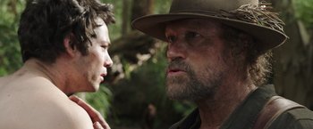 Movie still from “Love and Monsters” (2020), directed by Michael Matthews – A man in a hat is talking to another man in a hat; Close Up shot, Over the shoulder angle