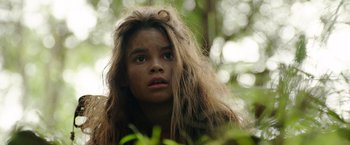 Movie still from “Love and Monsters” (2020), directed by Michael Matthews – A young girl with long brown hair in the woods; Close Up shot, Low angle