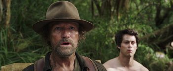 Movie still from “Love and Monsters” (2020), directed by Michael Matthews – A person wearing a hat with trees in the background; Close Up shot, Over the shoulder angle