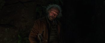 Movie still from “Love and Monsters” (2020), directed by Michael Matthews – A man in a brown jacket is holding a bicycle; Medium shot, Low angle