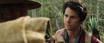 Movie still from “Love and Monsters” (2020), directed by Michael Matthews – A man standing in front of a tree looking at the camera; Close Up shot, Over the shoulder angle