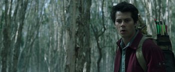 Movie still from “Love and Monsters” (2020), directed by Michael Matthews – A man standing next to a tree in the woods; Close Up shot, Low angle