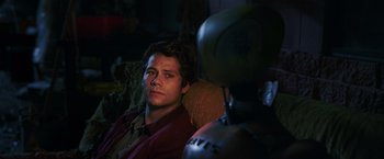 Movie still from “Love and Monsters” (2020), directed by Michael Matthews – A man sitting in a chair next to another man; Close Up shot, Over the shoulder angle