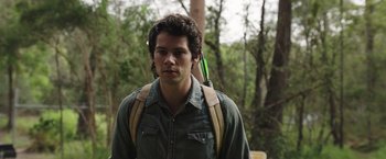 Movie still from “Love and Monsters” (2020), directed by Michael Matthews – A young man with a backpack is holding something in his hand; Close Up shot, Over the shoulder angle