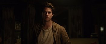 Movie still from “Love and Monsters” (2020), directed by Michael Matthews – A man in a brown jacket standing in a dark room; Close Up shot, Low angle