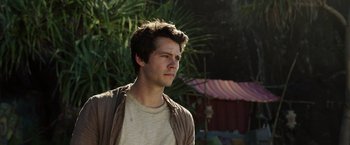 Movie still from “Love and Monsters” (2020), directed by Michael Matthews – A young man standing in front of some trees; Close Up shot, Low angle