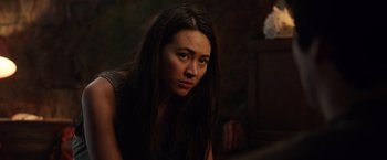 Movie still from “Love and Monsters” (2020), directed by Michael Matthews – A woman with long black hair sitting in a dark room; Close Up shot, Over the shoulder angle