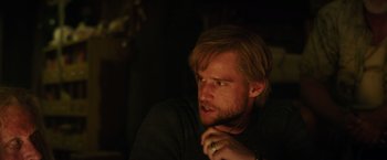 Movie still from “Love and Monsters” (2020), directed by Michael Matthews – A person sitting in a dark room; Close Up shot, Over the shoulder angle