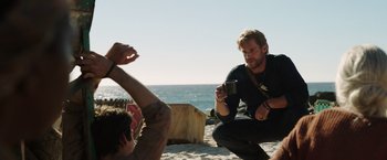 Movie still from “Love and Monsters” (2020), directed by Michael Matthews – Two men on the beach taking a picture of each other; Medium shot, Over the shoulder angle