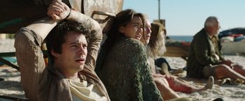 Movie still from “Love and Monsters” (2020), directed by Michael Matthews – A group of people sitting next to each other on a bench; Medium shot, Low angle