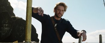 Movie still from “Love and Monsters” (2020), directed by Michael Matthews – A man with long hair and a beard wearing a sweater; Close Up shot, Low angle