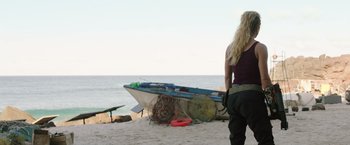 Movie still from “Love and Monsters” (2020), directed by Michael Matthews – A woman standing on the beach looking at a boat; Wide shot, Over the shoulder angle