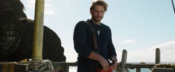 Movie still from “Love and Monsters” (2020), directed by Michael Matthews – A man standing next to a wooden fence; Medium shot, Over the shoulder angle
