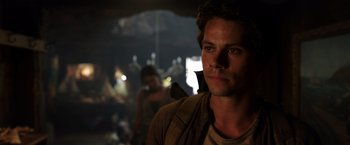 Movie still from “Love and Monsters” (2020), directed by Michael Matthews – A man with a bird on his shoulder in the dark; Close Up shot, Over the shoulder angle