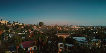 Movie still from “Love Hard” (2021), directed by Hernán Jiménez – A view of a city skyline at sunset; Extreme Wide shot, High angle