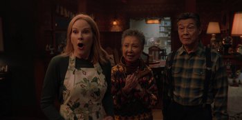 Movie still from “Love Hard” (2021), directed by Hernán Jiménez – A group of people standing next to each other in a room; Medium shot, Over the shoulder angle