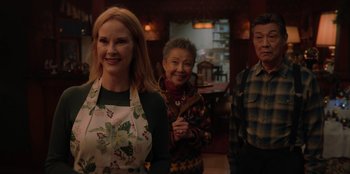 Movie still from “Love Hard” (2021), directed by Hernán Jiménez – A group of people standing next to each other in a room; Medium shot, Over the shoulder angle