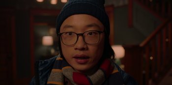 Movie still from “Love Hard” (2021), directed by Hernán Jiménez – A man wearing glasses and a hat and a scarf; Close Up shot, Over the shoulder angle