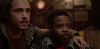 Movie still from “Love Hard” (2021), directed by Hernán Jiménez – Two men sitting next to each other in a room; Close Up shot, Over the shoulder angle