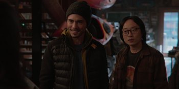 Movie still from “Love Hard” (2021), directed by Hernán Jiménez – A man and a woman standing next to each other; Medium shot, Over the shoulder angle