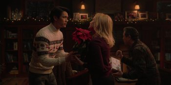 Movie still from “Love Hard” (2021), directed by Hernán Jiménez – A man and a woman holding a poinsettia flower; Medium shot, Over the shoulder angle