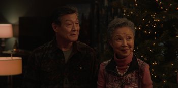 Movie still from “Love Hard” (2021), directed by Hernán Jiménez – An older man standing next to an older woman; Close Up shot, Over the shoulder angle