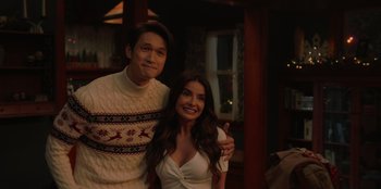 Movie still from “Love Hard” (2021), directed by Hernán Jiménez – A man and a woman posing for a picture; Medium shot, Over the shoulder angle