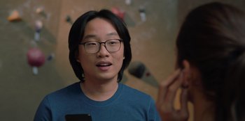 Movie still from “Love Hard” (2021), directed by Hernán Jiménez – A man in a blue shirt is holding a cell phone; Close Up shot, Over the shoulder angle