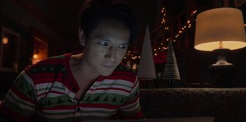 Movie still from “Love Hard” (2021), directed by Hernán Jiménez – A man looking at a computer screen in the dark; Close Up shot, Over the shoulder angle