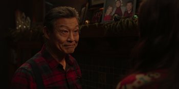 Movie still from “Love Hard” (2021), directed by Hernán Jiménez – An older man in a red and black plaid shirt; Close Up shot, Over the shoulder angle