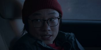 Movie still from “Love Hard” (2021), directed by Hernán Jiménez – A man wearing glasses and a red hat; Close Up shot, Over the shoulder angle