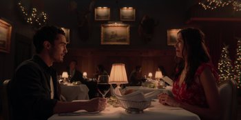 Movie still from “Love Hard” (2021), directed by Hernán Jiménez – A man and a woman sitting at a table with a glass of red wine; Medium shot, Over the shoulder angle