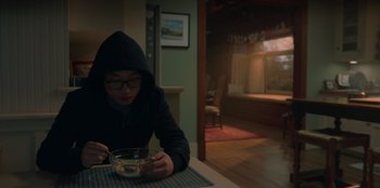 Movie still from “Love Hard” (2021), directed by Hernán Jiménez – A man sitting at a table with a bowl of cereal; Medium shot, High angle