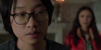 Movie still from “Love Hard” (2021), directed by Hernán Jiménez – A person wearing glasses and a sweater; Close Up shot, Over the shoulder angle